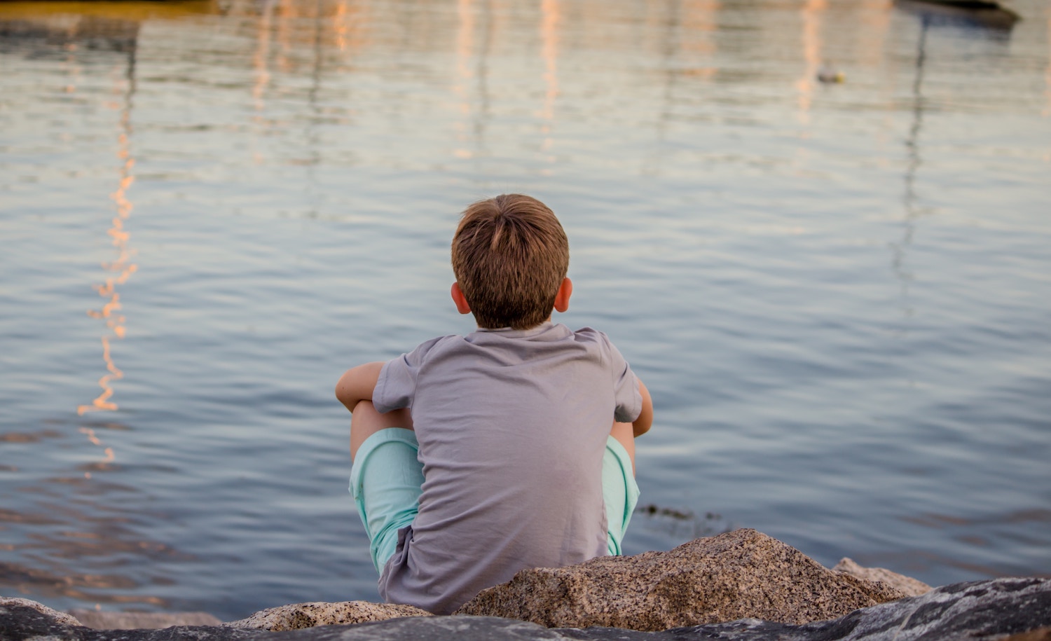 a highly sensitive boy sits by a lake