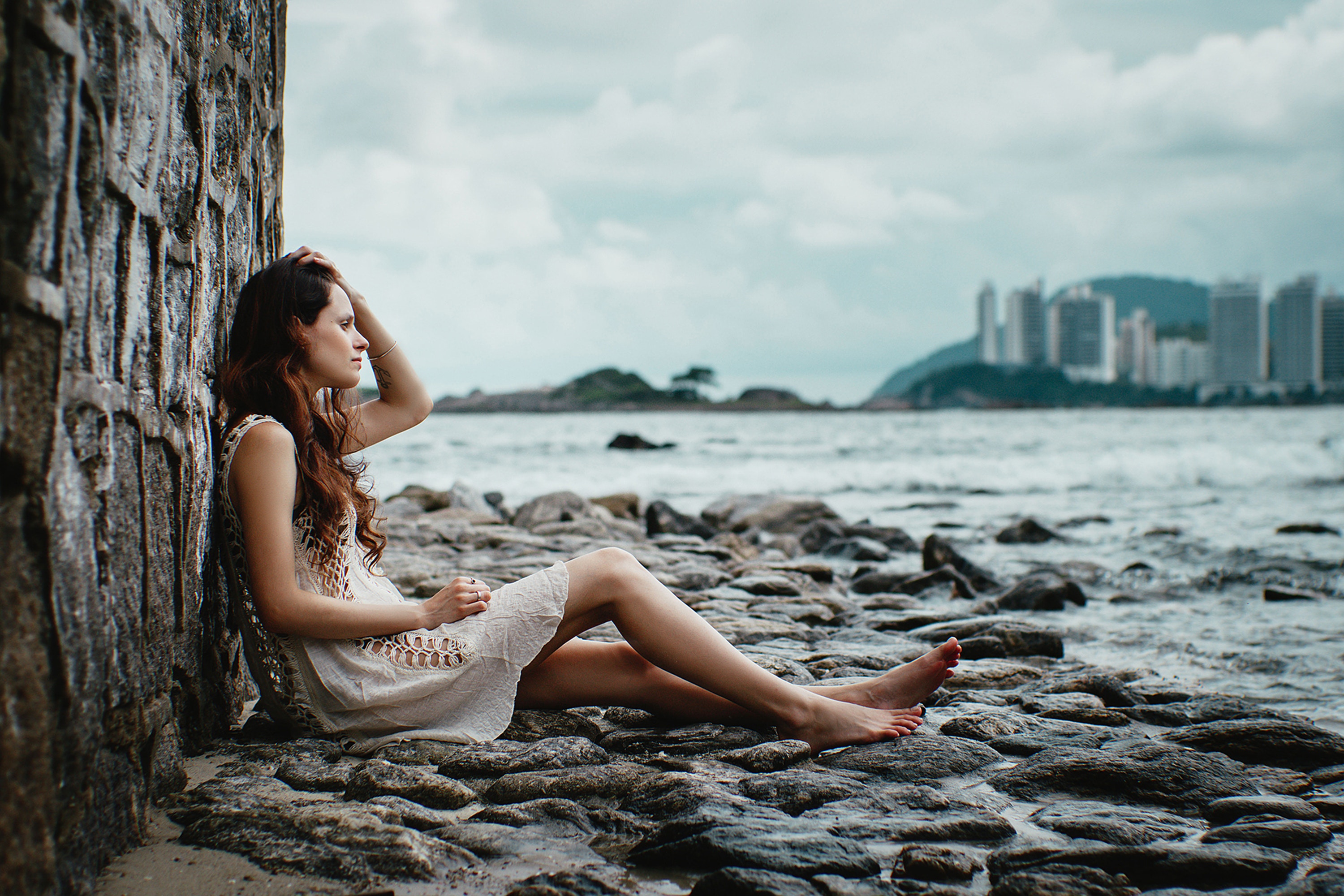 A highly sensitive woman sits by the ocean trying to deal with negative emotions.