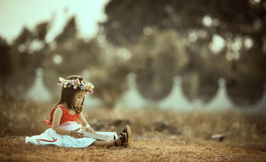 A highly sensitive child sitting outdoors alone and reading