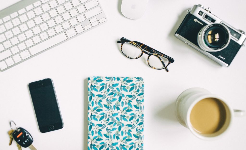 a notebook, coffee cup, and keyboard represent a highly sensitive person achieving their goals using the mind body heart system
