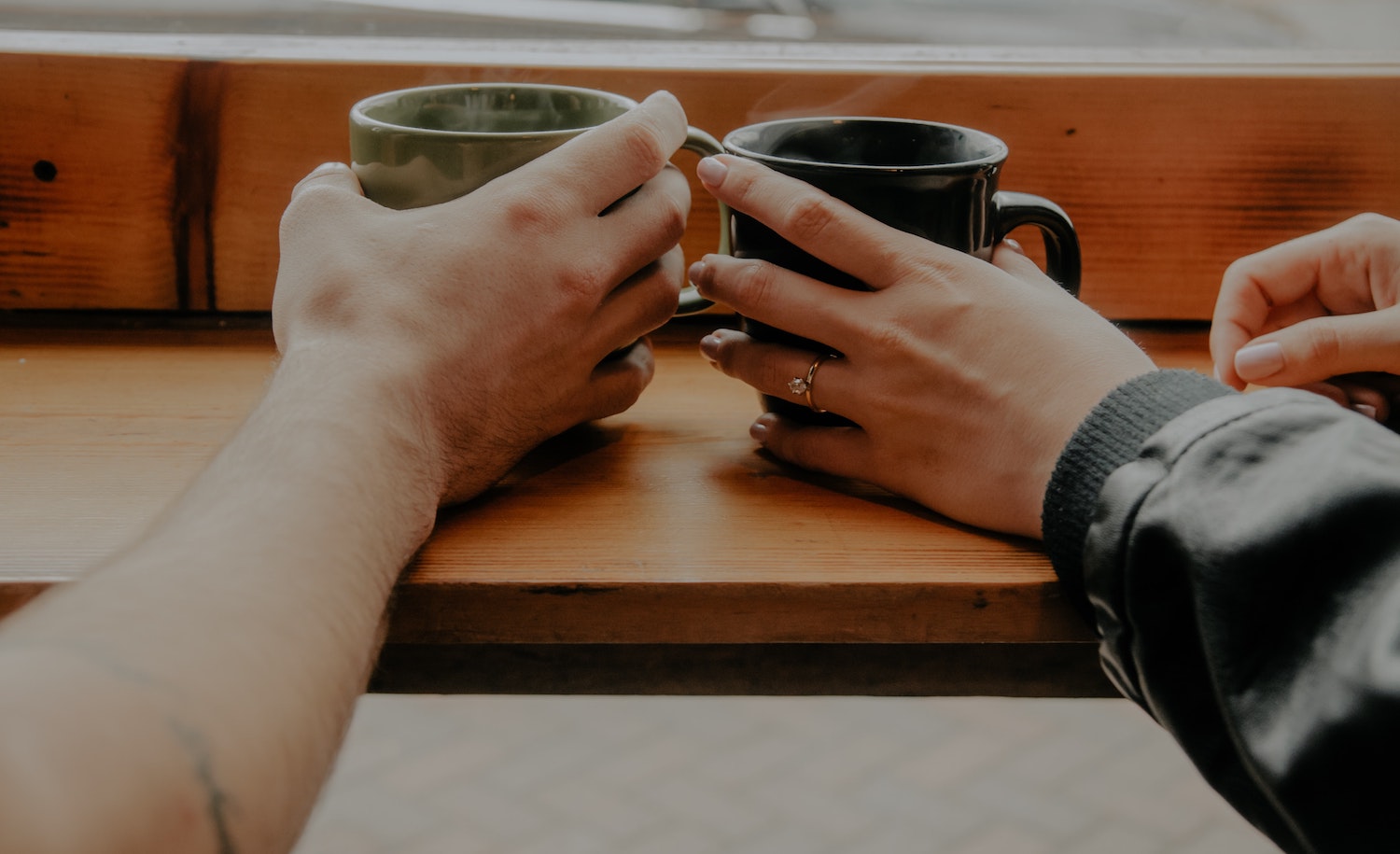 Two highly sensitive people touch hands over coffee in a time of crisis