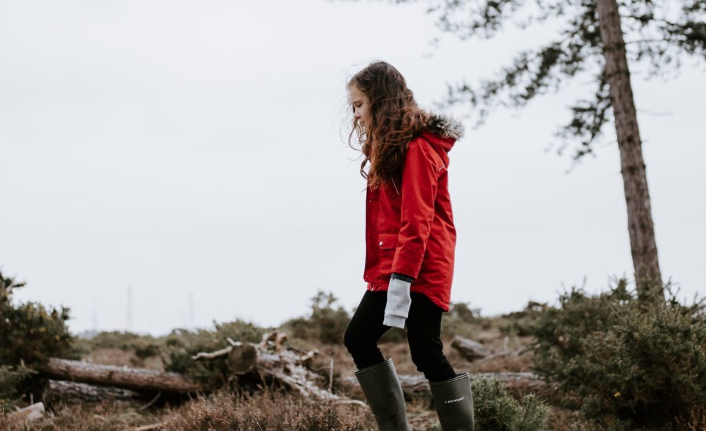 A young highly sensitive person walking alone outside after dealing wth a bad childhood