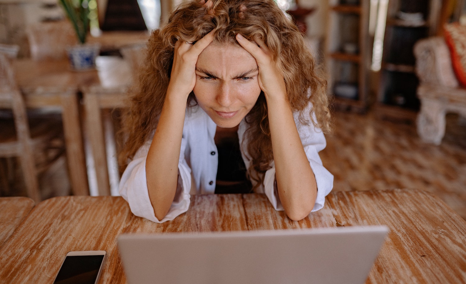A woman experiencing a flood of frustration, stress and worry while working at her computer in her home office