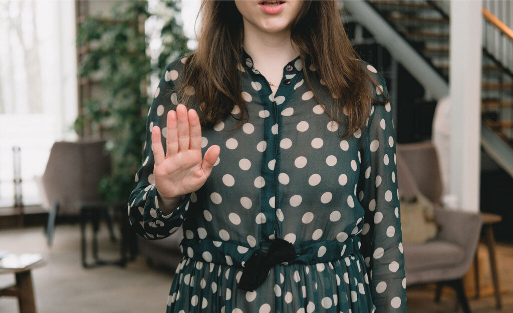 A highly sensitive person making a “stop” sign with her hand