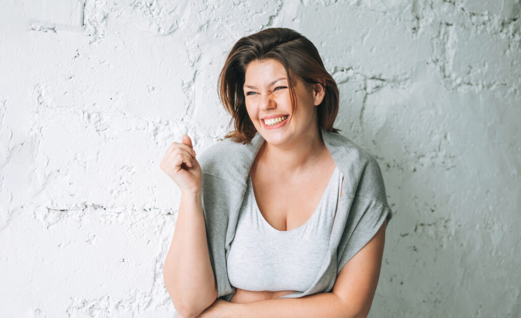 A highly sensitive person smiling after recharging her emotional battery.