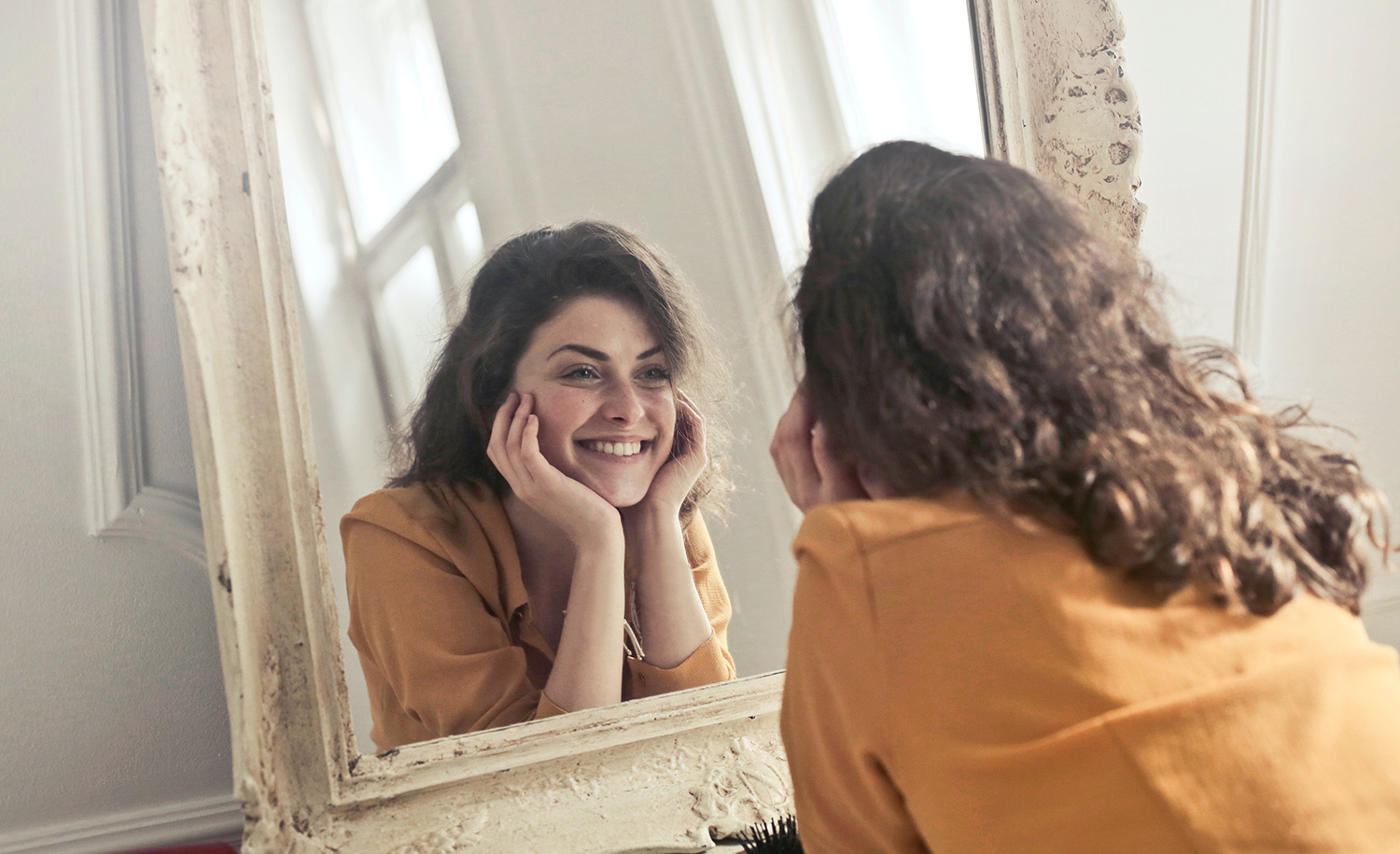 A highly sensitive person smiling at herself in the mirror