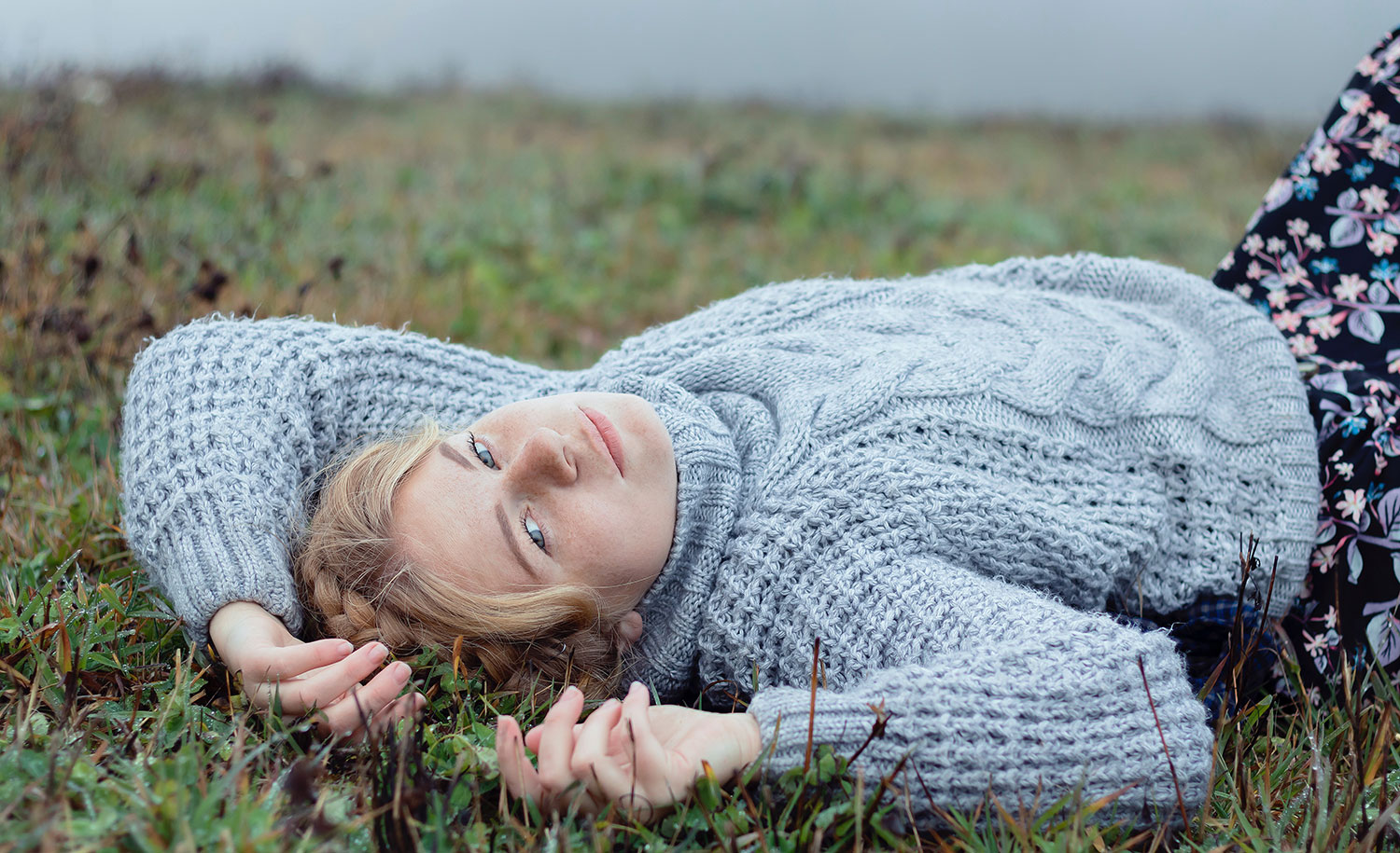 A highly sensitive woman lies in the grass
