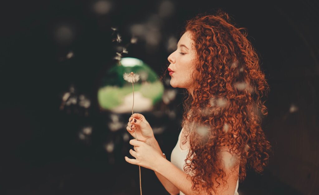 A highly sensitive person blows petals from a flower