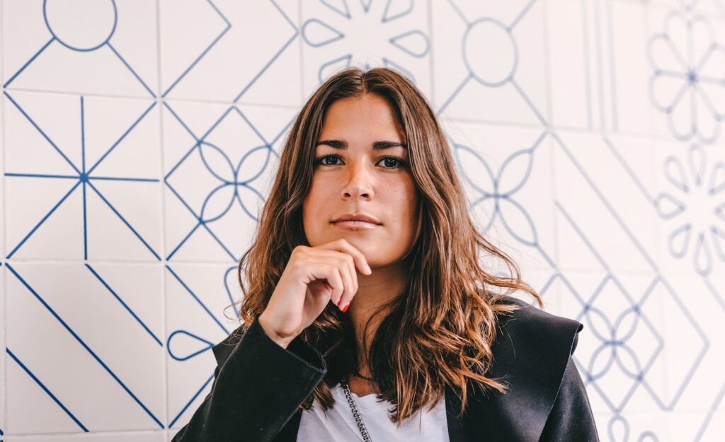 A highly sensitive person sitting with her hand on her chin in a thinking posture