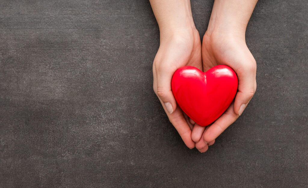 A hand holding out a heart to symbolize learning to love yourself