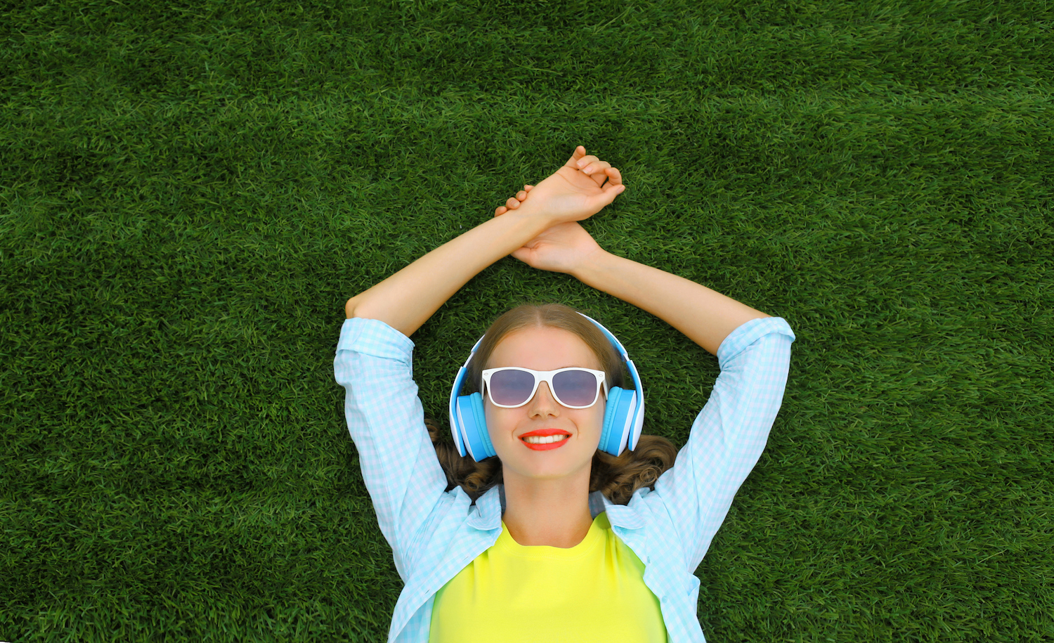 A highly sensitive person laying on grass and listening to music