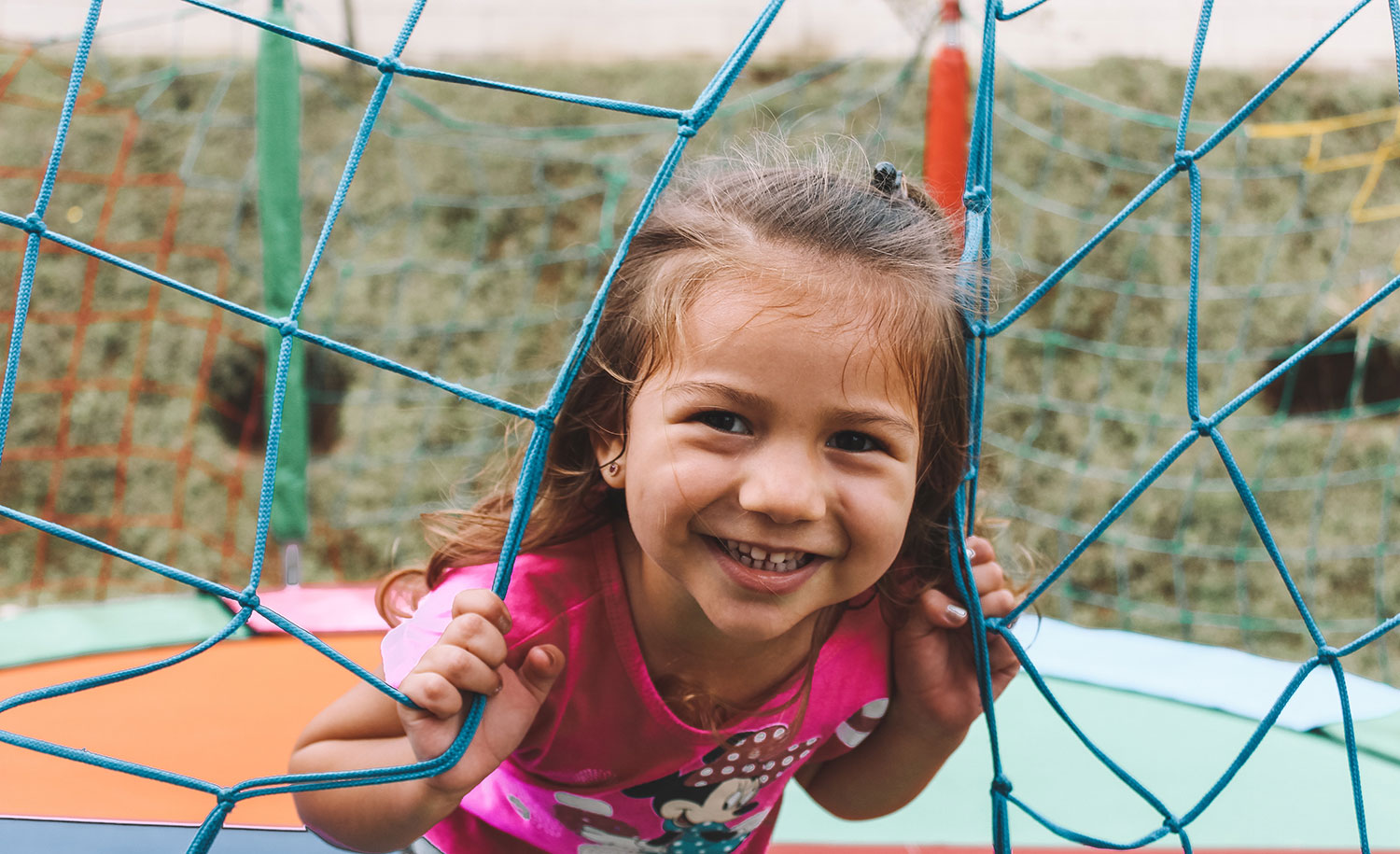 A young girl on a trampoline, smiling