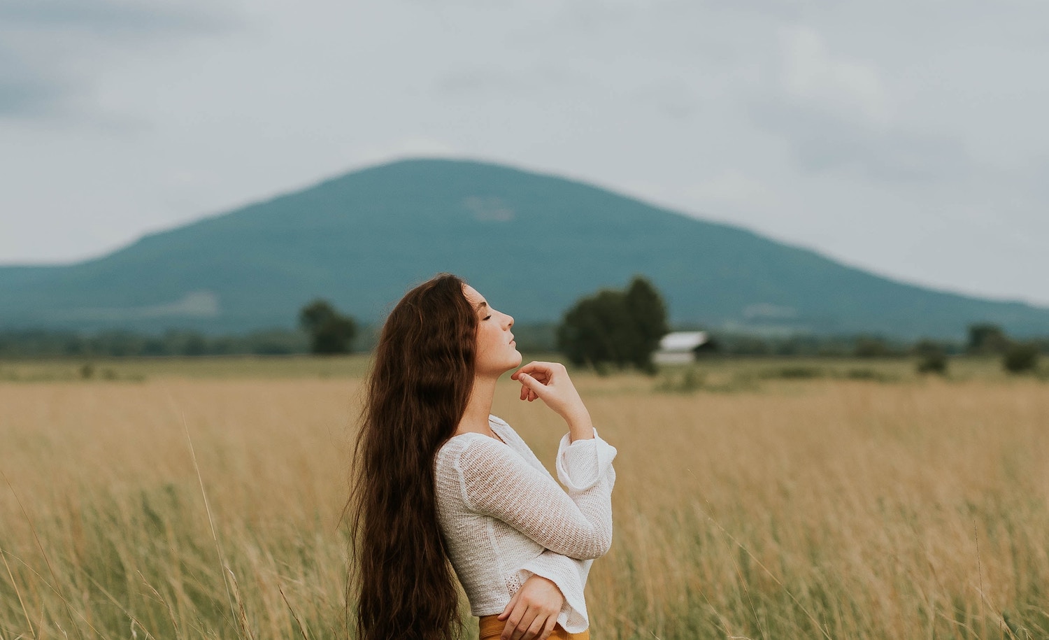 A highly sensitive person woman gazing off into the distance in a field