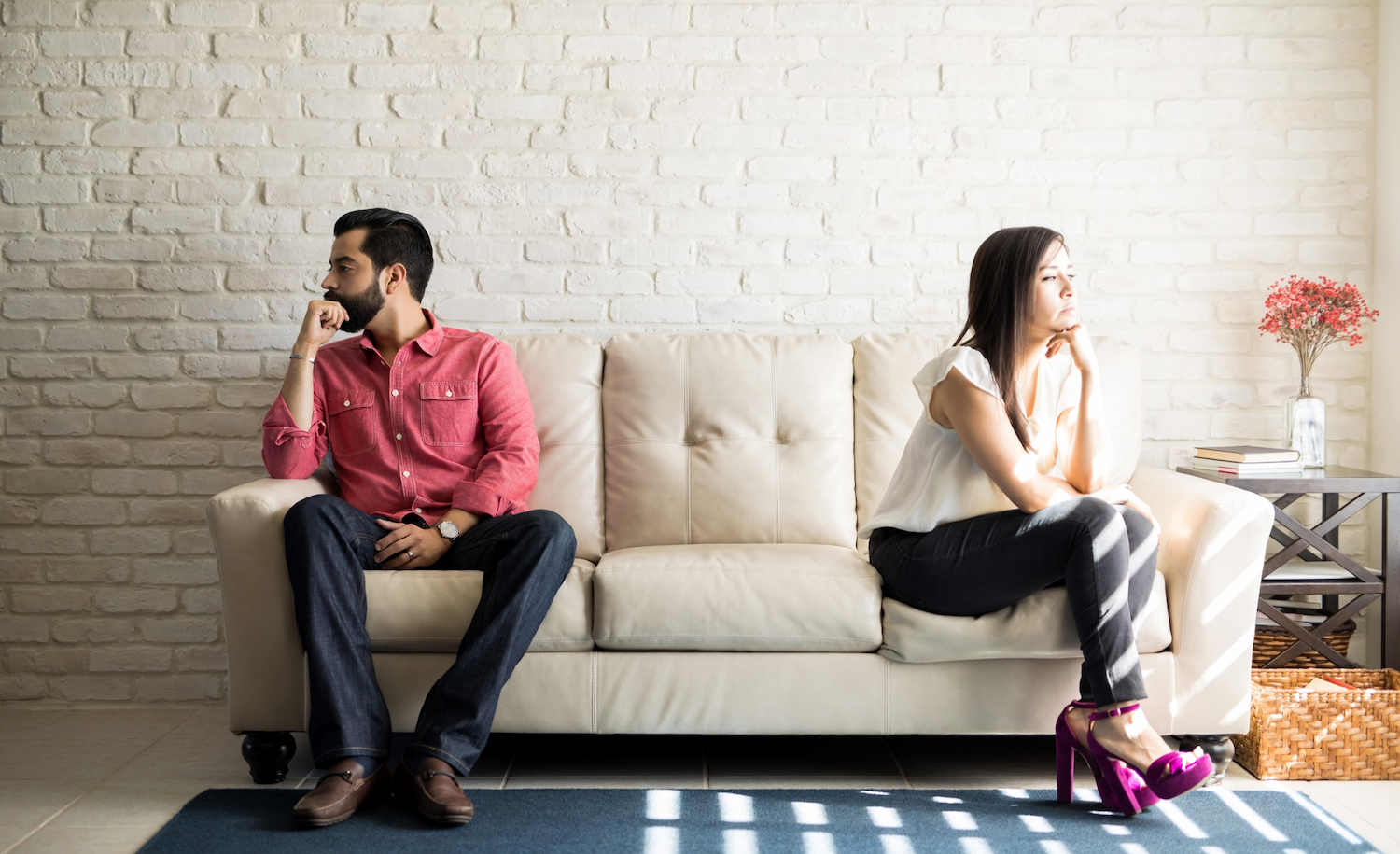 A highly sensitive person sits opposite their partner on a couch as they break up