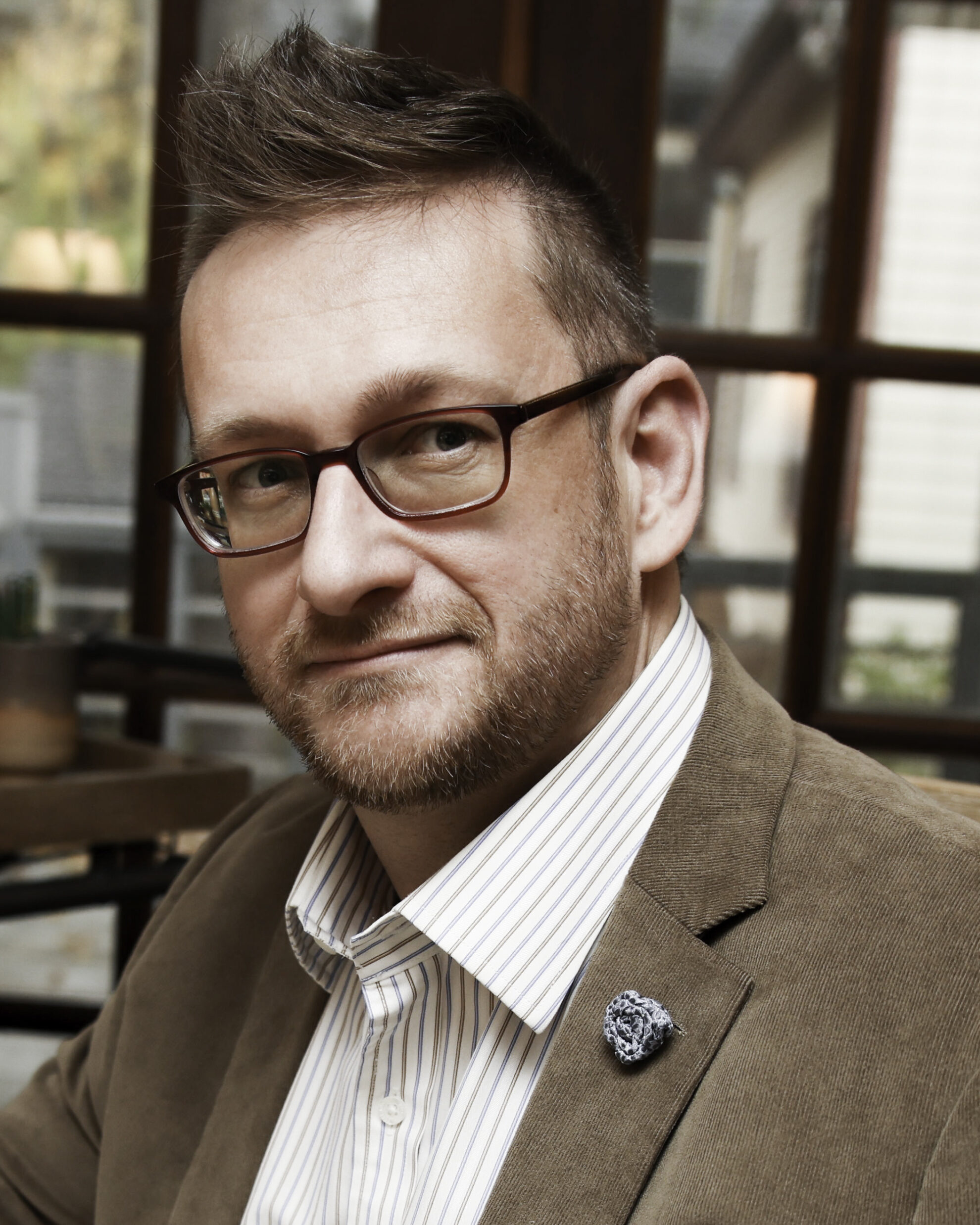 Photo of Andre Sólo, bestselling author and creator of Sensitive Refuge, the world's largest community for highly sensitive people, sitting at his desk.